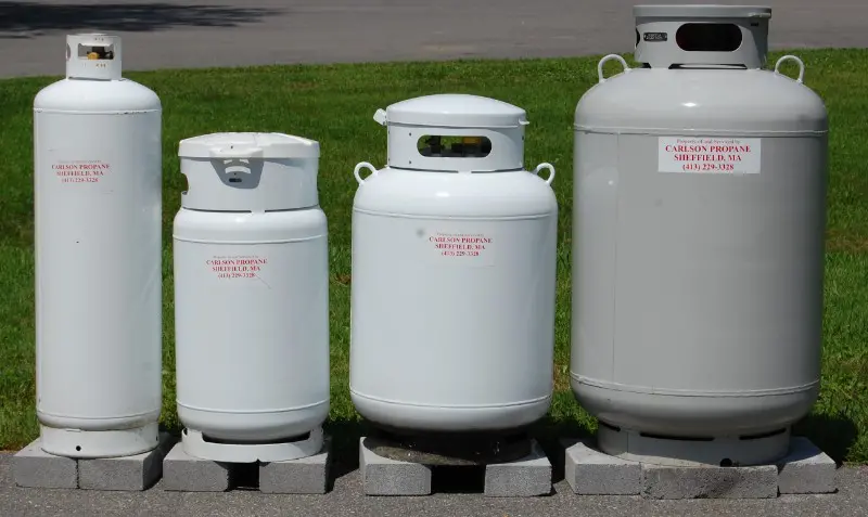 A 20 lb grill bottle next to a 100 lb propane cylinder for generator fuel